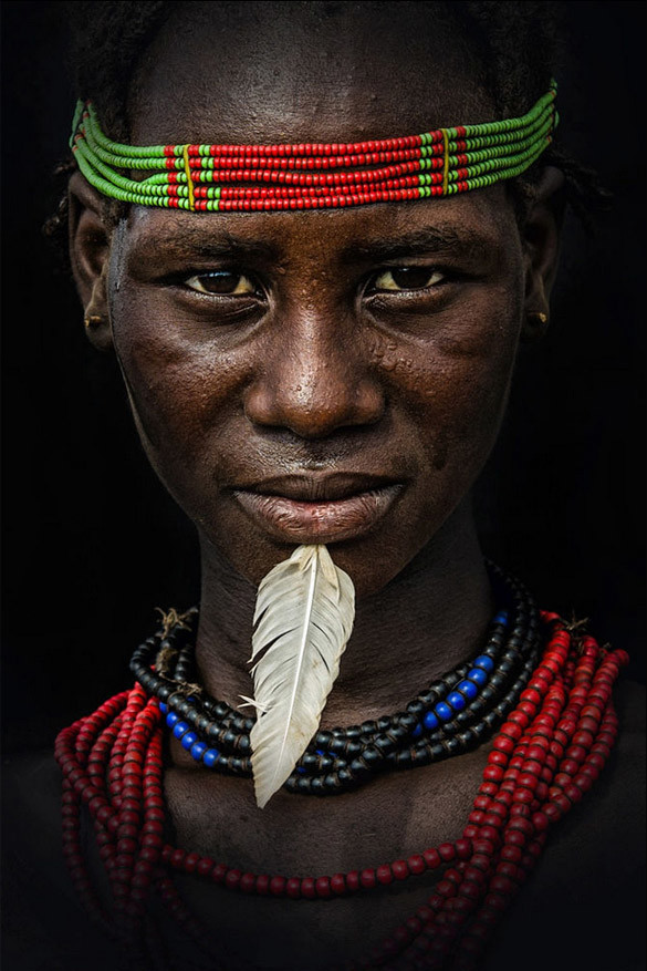 Een Dassanech vrouw. Ze woont in het gebied van de Omorivier vlakbij Omorate in Zuid-Ethiopië. Ze zijn altijd kleurrijk uitgedost met hoofdaccessoires en juwelen en sommigen steken zelfs een veer in hun kin. Het doet denken aan een eerbetoon voor hun meest waardevolle bezit, de geit.