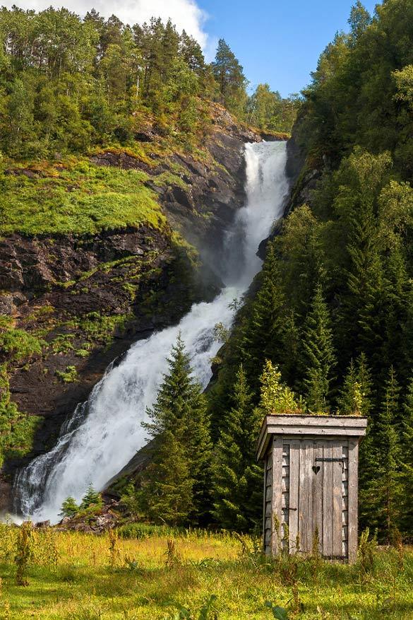 Toilet aan de Huldefossen waterval, Noorwegen: wie niet dringend moet, heeft toch niet veel nodig met een toilet als dit, geïnstalleerd voor deze indrukwekkende waterval in de buurt van Førde in Noorwegen. Het geluid van duizenden liters water die over een hoogte van 90 meter naar beneden vallen overstelpen alvast ongewenste geluiden. In Noorwegen vind je trouwens negen van de 20 hoogste watervallen ter wereld. © Roelof Nijholt