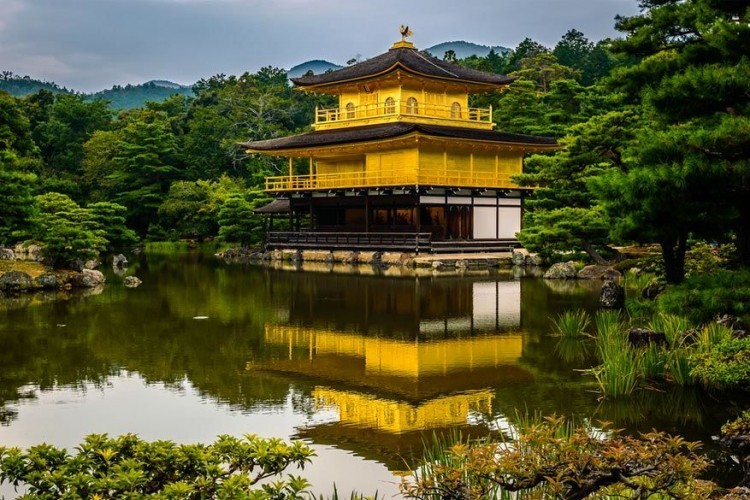 De Tempel van het Gouden Paviljoen in Kioto, Japan: ook wel de Kinkaku-ji tempel genoemd. Het huidige gebouw is een replica uit de 12de eeuw, dat in 1950 in brand gestoken werd door een monnik. Het paviljoen werd herbouwd en behalve de bovenste verdieping werden ook de muren en pilaren op de 1ste etage voorzien van bladgoud. De tempel is een van de beroemdste en daarmee meest bezochte toeristische attractie van Japan en Kioto. © Marco Patelli