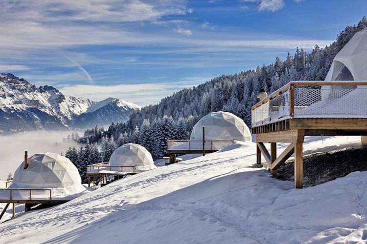Iglocamping in Valais, Zwitserland: zelf in de winter kun je kamperen, meer bepaald op 1.400 meter hoogte in het Zwitserse Valais. Daar staan 15 luxueuze witte iglotenten in de sneeuw opgesteld om ’s winters helemaal één te worden met de natuur. Je hebt zicht op de Rhônevallei en mag zelfs skiën op de privéskipiste van het resort. ’s Avonds krijg je het terug warm met een schapenwollendeken en een kacheltje in de tent. © Whitepod