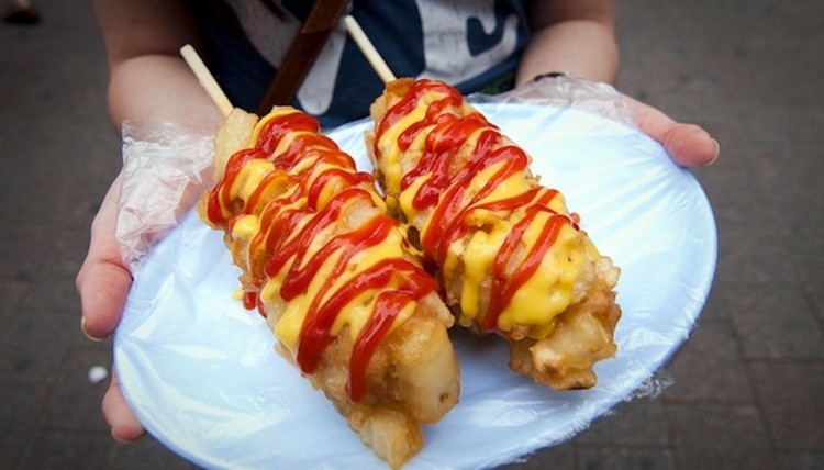 Korea: een worst met daarrond gesneden frietjes gefrituurd op een stokje en afgewerkt met ketchup. © firstwefeast.com