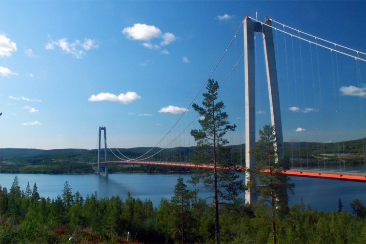 Högakustenbron in Zweden: deze hangbrug staat zeker ergens bovenaan in het lijstje ‘hoogste hangbruggen in Europa’ met een lengte van 1.867 meter. Ze is eveneens ook de tweede langste in Scandinavië. De brug werd gebouwd over de rivier Ångermanälven en verbindt zo de gemeentes Härnösand en Kramfors in het noorden van Zweden. © Wikimedia Commons
