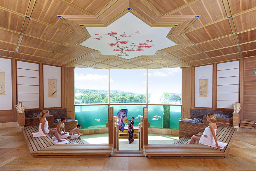 De grootste sauna ter wereld kijkt op uit een aquarium vol koi vissen!